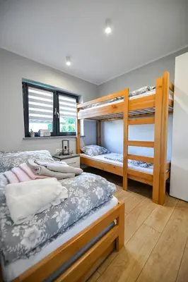 a bedroom with two bunk beds and a desk at Domki Pod Skarpą Zator in Zator