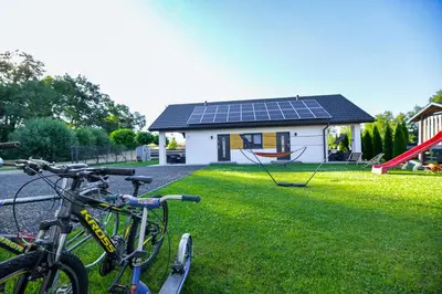 two bikes parked in front of a house with solar panels at Domki Pod Skarpą Zator in Zator