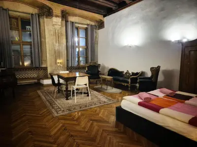 a room with a bed and a table and chairs at Main Square 18 King Apartament in Kraków