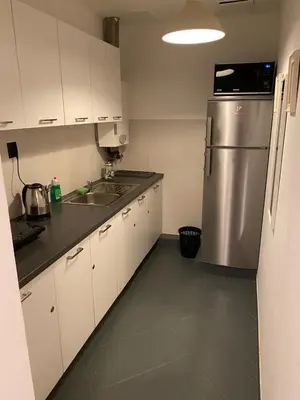 a kitchen with white cabinets and a stainless steel refrigerator at Main Square 18 King Apartament in Kraków