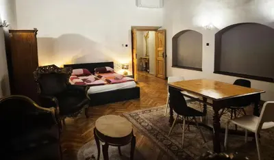 a living room with a bed and a table and chairs at Main Square 18 King Apartament in Kraków