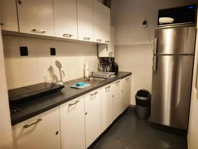 a kitchen with white cabinets and a stainless steel refrigerator at Main Square 18 King Apartament in Kraków