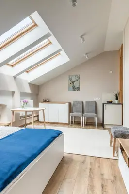 a bedroom with a bed and a table and chairs at Dluga Apartments in Kraków