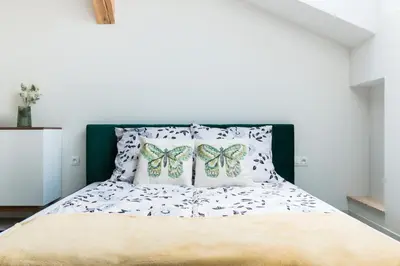 a bedroom with a bed with butterfly pillows on it at Dluga Apartments in Kraków