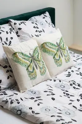 a bed with three pillows with butterflies on it at Dluga Apartments in Kraków