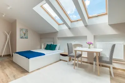 a bedroom with a bed and a table at Dluga Apartments in Kraków