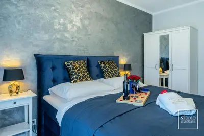 a bedroom with a blue bed with a blue head board at Exclusive Gold Apartment in Kraków