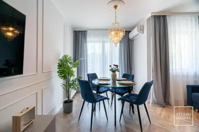 a dining room with a table and blue chairs at Exclusive Gold Apartment in Kraków