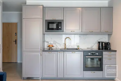 a kitchen with white cabinets and a sink at Exclusive Gold Apartment in Kraków