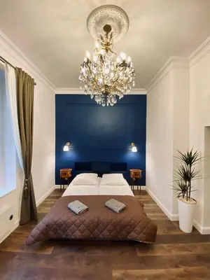 a bedroom with a large bed and a chandelier at Kochanowskiego Apartment - Topolove Rooms & Apartments in Kraków