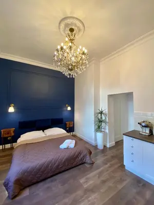 a bedroom with a large bed and a chandelier at Kochanowskiego Apartment - Topolove Rooms & Apartments in Kraków