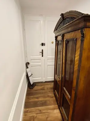 a hallway with a wooden cabinet next to a door at Kochanowskiego Apartment - Topolove Rooms & Apartments in Kraków