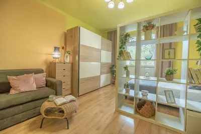 a living room with a couch and a book shelf at Apartament Premium Salt in Wieliczka