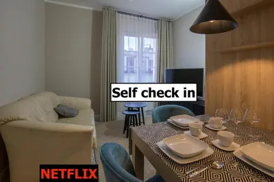 a living room with a table and a set check in at Na Skałce Apartment in Kraków