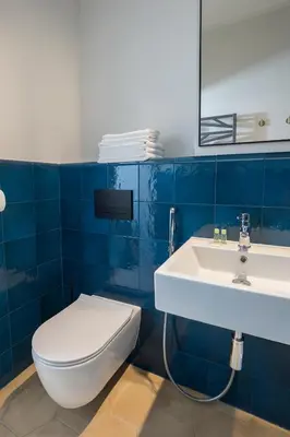 a bathroom with a white toilet and a sink at Na Skałce Apartment in Kraków