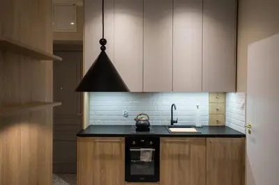 a kitchen with a stove and a black counter top at Na Skałce Apartment in Kraków