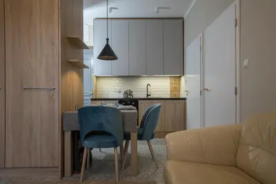 a kitchen with a table and chairs and a couch at Na Skałce Apartment in Kraków