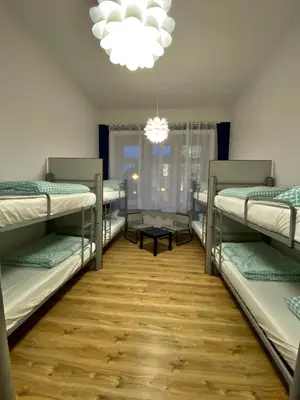 a room with four bunk beds and a chandelier at SKY HOSTEL in Kraków