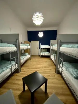 a room with four bunk beds and a table at SKY HOSTEL in Kraków