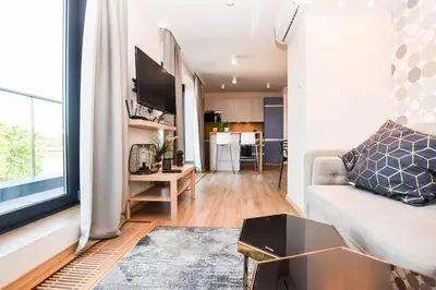 a living room with a couch and a large window at Apartamenty nad Wisłą in Kraków