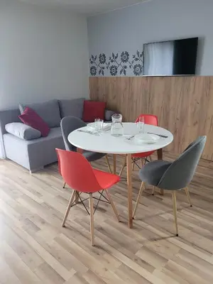 a table and chairs in a living room with a couch at Willa Wiesia Rabka Zdrój in Rabka