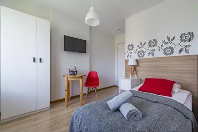 a bedroom with a bed and a red chair at Willa Wiesia Rabka Zdrój in Rabka