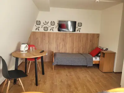a small bedroom with a small table and a bed at Willa Wiesia Rabka Zdrój in Rabka