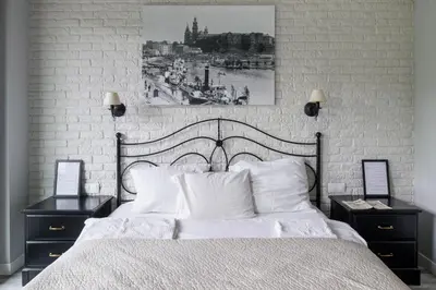 a bedroom with a white bed with two nightstands and a picture at Przy Wawelu z Garażem w cenie in Kraków