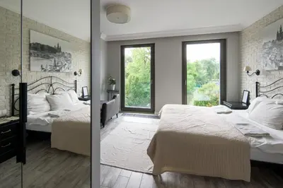 two beds in a bedroom with two windows at Przy Wawelu z Garażem w cenie in Kraków