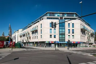 a large white building on a city street with a traffic light at Przy Wawelu z Garażem w cenie in Kraków