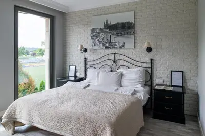 a bedroom with a bed and a brick wall at Przy Wawelu z Garażem w cenie in Kraków