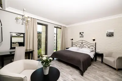 a bedroom with a bed and a living room at Native Apartments Sukiennicza 8 in Kraków