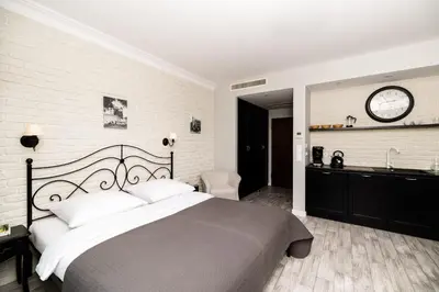 a bedroom with a large bed and a brick wall at Native Apartments Sukiennicza 8 in Kraków