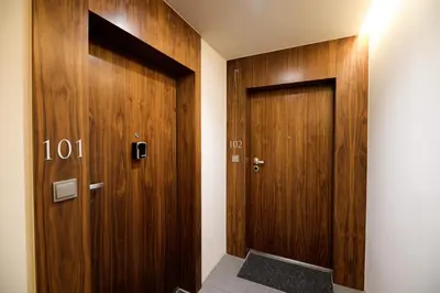 a hallway with two wooden doors in a room at Native Apartments Sukiennicza 8 in Kraków