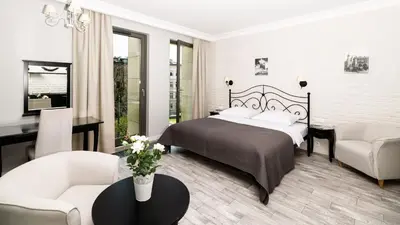 a bedroom with a bed and a living room at Native Apartments Sukiennicza 8 in Kraków