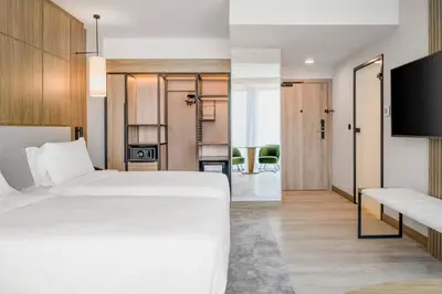 a bedroom with a white bed and a tv at AC Hotel by Marriott Krakow in Kraków