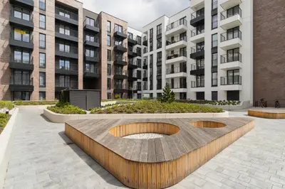 a courtyard with two benches in front of buildings at Apartments Steam Park Old Town Cracow by Noclegi Renters in Kraków
