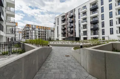 a walkway in a city with tall buildings at Apartments Steam Park Old Town Cracow by Noclegi Renters in Kraków