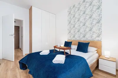 a bedroom with a blue bed with a table on it at Apartments Steam Park Old Town Cracow by Noclegi Renters in Kraków