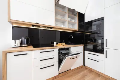 a kitchen with white cabinets and a sink at Apartments Steam Park Old Town Cracow by Noclegi Renters in Kraków