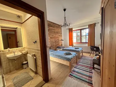 a room with a bed and a sink and a bathroom at U Kapiarza in Klikuszowa