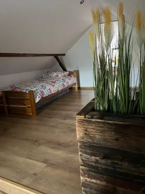 a bedroom with a bed and a planter with plants at Malinowa Chatka in Jankowice