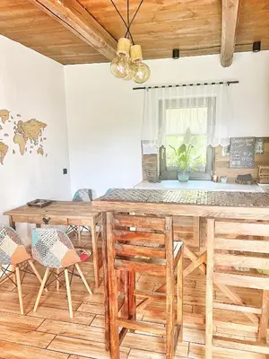 a dining room with a wooden table and chairs at Malinowa Chatka in Jankowice