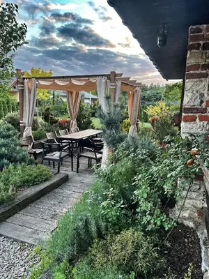 a patio with a table and chairs in a garden at Malinowa Chatka in Jankowice