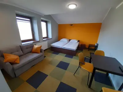 a room with a couch and a bed and a table at Willa Czajki in Oświęcim