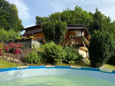 a house with a swimming pool in front of a house at Rudera u Sióstr DREWNIANY DOMEK Stróża in Stróża