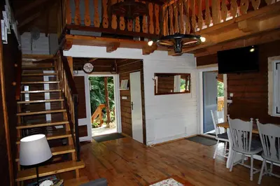 a living room with a staircase in a cabin at Rudera u Sióstr DREWNIANY DOMEK Stróża in Stróża