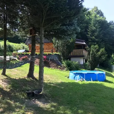 a yard with a tree and a house at Rudera u Sióstr DREWNIANY DOMEK Stróża in Stróża