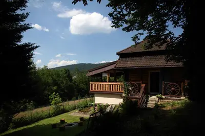 a log cabin with a porch and a balcony at Rudera u Sióstr DREWNIANY DOMEK Stróża in Stróża