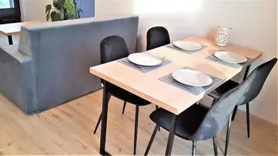 a dining room table with black chairs and white plates on it at MOGILSKA Apartments near Tauron Arena Krakow in Kraków